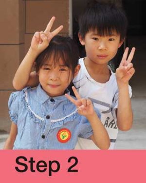 Boy and girl from China making peace sign