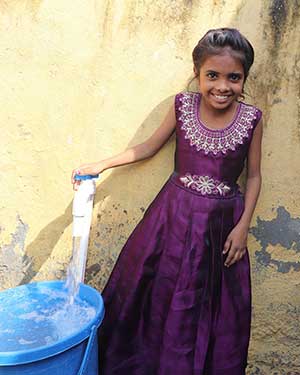 girl in front of safe water tap