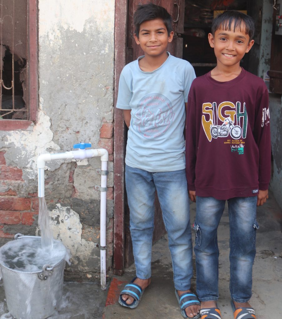 boys beside water tap